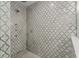 Close up of walk-in shower with decorative tile walls and flooring, rain shower head and handheld sprayer at 2922 Carmia Dr, Orlando, FL 32806