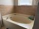 A primary bathroom with a bathtub, vanity, and tile, offering a clean and updated look at 3024 Natoma Way, Orlando, FL 32825