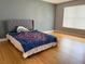 Spacious bedroom with hardwood floors and a large window for ample natural light and patterned bedspread at 3024 Natoma Way, Orlando, FL 32825