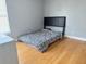 A bedroom with wood flooring is well-lit by a window and holds a cozy bed at 3024 Natoma Way, Orlando, FL 32825