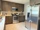 This kitchen boasts stainless steel appliances, wooden cabinets, and granite countertops at 3024 Natoma Way, Orlando, FL 32825