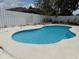 Inviting pool with white concrete surround and white wood fence; perfect for relaxation and outdoor enjoyment at 3024 Natoma Way, Orlando, FL 32825