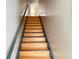 An indoor stairway with wooden steps and gray wall, leading to the home's upper level at 3024 Natoma Way, Orlando, FL 32825