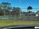 Community tennis courts are surrounded by a fence and set against a backdrop of trees and a clear sky at 4251 Pinebark Ave # 17-3, Orlando, FL 32811