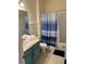 Bathroom with a blue vanity, shower with blue curtain, tile flooring, and stacked towels at 4573 Ada Ln, Kissimmee, FL 34746