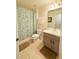 Bathroom with a shower-tub combo, gray cabinets, and tile flooring at 4573 Ada Ln, Kissimmee, FL 34746