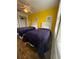 Bedroom with yellow accent wall featuring two twin beds with wood-look laminate flooring at 4573 Ada Ln, Kissimmee, FL 34746