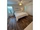 Bright bedroom featuring a queen bed, ceiling fan, and closet with wood-look laminate flooring at 4573 Ada Ln, Kissimmee, FL 34746