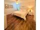 Bright bedroom with wood floors, ceiling fan, and a queen bed with white bedding at 4573 Ada Ln, Kissimmee, FL 34746