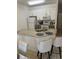Kitchen view with granite countertops, stainless steel sink, white cabinetry and seating at the breakfast bar at 4573 Ada Ln, Kissimmee, FL 34746