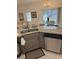 Kitchen view with granite countertop, a stainless-steel dishwasher, and view of the pool beyond dining area at 4573 Ada Ln, Kissimmee, FL 34746