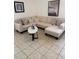 Comfortable living room featuring a sectional sofa, oval coffee table and neutral decor on tile flooring at 4573 Ada Ln, Kissimmee, FL 34746