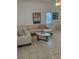 Bright living room with a neutral sectional, tile floors, white walls and decorative wall art at 4573 Ada Ln, Kissimmee, FL 34746