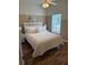 Bright main bedroom with a comfortable bed and dark wood-look floors at 4573 Ada Ln, Kissimmee, FL 34746