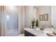 Bright bathroom featuring a white vanity, framed botanical art, and a shower with a modern, neutral-toned curtain at 4711 Coral Harbour Rd, Kissimmee, FL 34758