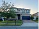 Well-manicured two-story home with solar panels, brick driveway, and attached two car garage at 4783 Riverwalk Dr, St Cloud, FL 34771