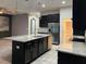 Well-equipped kitchen with stainless steel appliances, dark cabinets, island and granite countertops at 4783 Riverwalk Dr, St Cloud, FL 34771