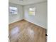 Bright bedroom featuring hardwood floors, white walls, and two windows at 701 N 4Th St, Haines City, FL 33844