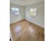 A bedroom features wood-look flooring, white walls, and two windows at 701 N 4Th St, Haines City, FL 33844