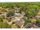 A high angle aerial view of a neighborhood with mature trees, and a house that has a screened-in pool at 704 Briarwood Dr, Winter Springs, FL 32708