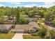 Aerial view of a charming home with mature landscaping, large driveway, fenced yard, and quiet street at 704 Briarwood Dr, Winter Springs, FL 32708