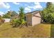 Exterior view of a tan home with mature tropical landscaping, side yard, and a sunny sky at 704 Briarwood Dr, Winter Springs, FL 32708