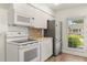 Bright kitchen featuring white appliances, cabinets, and a window with plenty of natural light at 704 Briarwood Dr, Winter Springs, FL 32708