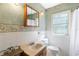Bathroom with white tiled walls, green upper walls, sink and vanity, and a window for natural light at 718 31St St, Orlando, FL 32805