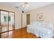 Bedroom with hardwood floors, daybed, ceiling fan, closet with mirrored doors, and view to another room at 718 31St St, Orlando, FL 32805