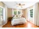 Cozy bedroom featuring hardwood floors, a ceiling fan, and three windows providing natural light at 718 31St St, Orlando, FL 32805