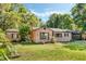 Inviting single-story brick home with lush green lawn, mature trees, and traditional architectural details at 718 31St St, Orlando, FL 32805