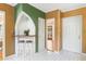 View of kitchen bar with arch, white-and-black tile floors, adjacent to an entrance, and white front door at 718 31St St, Orlando, FL 32805