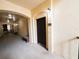 Hallway featuring arched entryways, beige textured walls, carpeted floor, and a dark wood entry door with a '1218' sign at 8276 Maritime Flag St # 201, Windermere, FL 34786