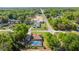 Aerial view of the home showing the pool, neighboring houses, and the surrounding greenery at 8499 Se 155Th, Summerfield, FL 34491