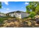Exterior view of the backyard featuring a white vinyl fence, pool enclosure, and mature trees at 8499 Se 155Th, Summerfield, FL 34491