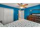 Bright bedroom with blue walls, ceiling fan, and white closets providing lots of storage space at 8499 Se 155Th, Summerfield, FL 34491