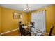 Formal dining room with a glass table, seating for four, and a modern chandelier above on hardwood floors at 8499 Se 155Th, Summerfield, FL 34491