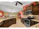 Open kitchen featuring stainless steel appliances, granite counters, and tile flooring looking into the living room at 8499 Se 155Th, Summerfield, FL 34491