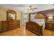 Spacious main bedroom with luxurious wooden furniture, ceiling fan, and lots of natural light at 8499 Se 155Th, Summerfield, FL 34491