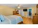 Bedroom featuring hardwood floors, dresser, and access to bathroom with tile shower at 8499 Se 155Th, Summerfield, FL 34491