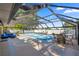 Covered swimming pool with blue lounge seating and an outdoor dining area at 8499 Se 155Th, Summerfield, FL 34491