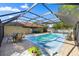 Covered pool area with a view of the house, sky, trees and plenty of lounging furniture at 8499 Se 155Th, Summerfield, FL 34491