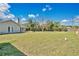 Expansive backyard showcasing ample green space, a fire pit and partial shade for outdoor enjoyment at 8703 Grandee Dr, Orlando, FL 32829