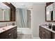 Traditional bathroom with dual vanities, shower-tub combo and wood-look floors at 8703 Grandee Dr, Orlando, FL 32829