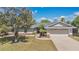 Charming single-story home with a well-manicured lawn, mature trees, and an attached two-car garage at 8703 Grandee Dr, Orlando, FL 32829