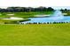 Picturesque golf course view with lush green grass, water feature, sand traps, and well-maintained landscaping at 8908 Azalea Sands Ln, Davenport, FL 33896