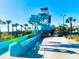 Community water park featuring thrilling slides, lush landscaping, and palm trees on a sunny day at 8908 Azalea Sands Ln, Davenport, FL 33896