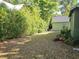 A view of a leafy and peaceful backyard featuring a detached garage, mature foliage, and lawn at 1000 Elmwood St, Orlando, FL 32801