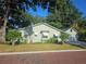 Side view of light green house with awnings, chimney and a detached two-car garage at the end of a concrete driveway at 1000 Elmwood St, Orlando, FL 32801