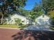 Charming light green home with a detached two-car garage and brick-paved street and a well-manicured lawn at 1000 Elmwood St, Orlando, FL 32801